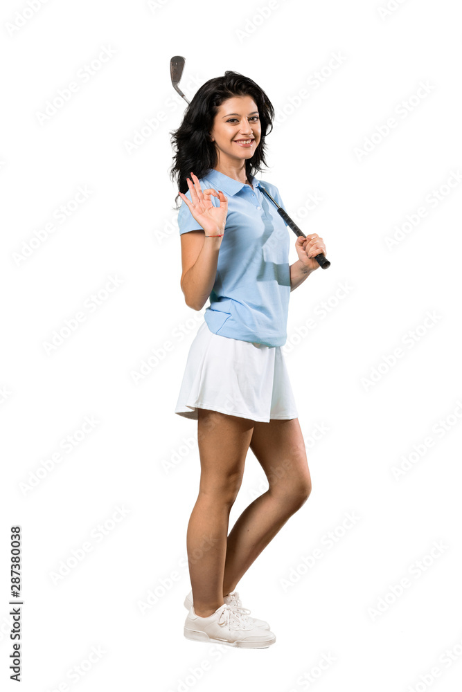 A full-length shot of a Young golfer woman showing ok sign with fingers over isolated white background A full-length shot of a Young golfer woman showing ok sign with fingers over isolated white background
