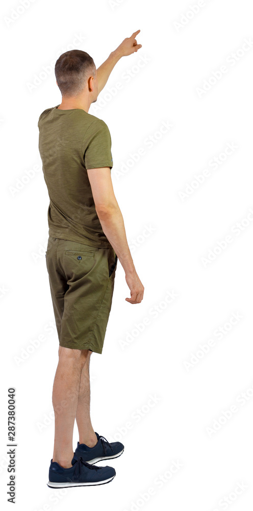 Back view of going handsome man in shorts pointing. Back view of going handsome man in shorts pointing.