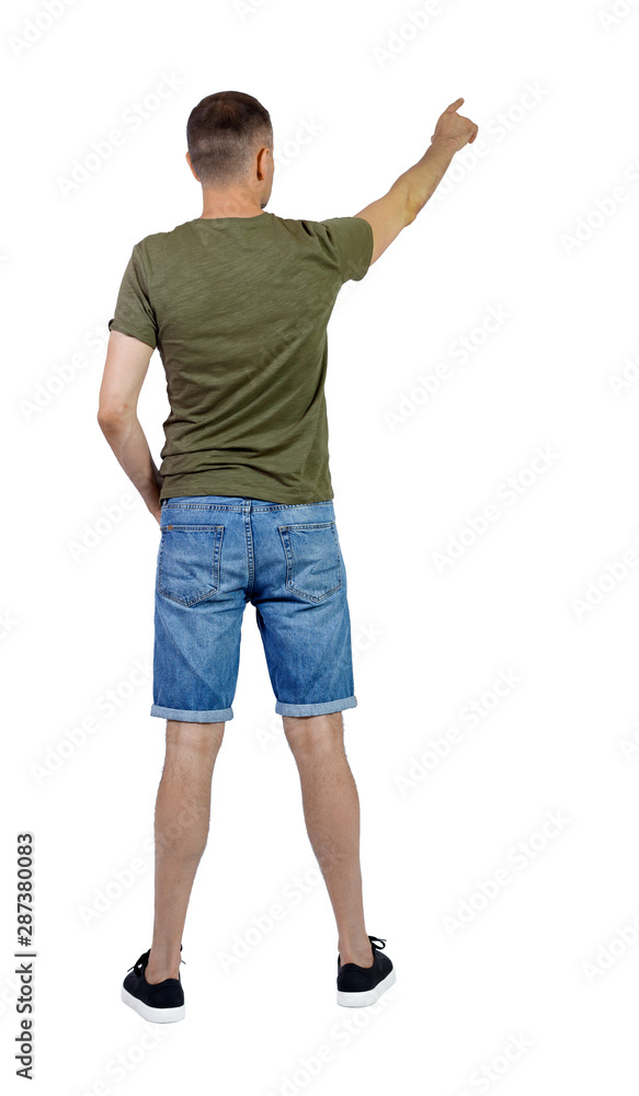 Back view of going handsome man in shorts pointing. Back view of going handsome man in shorts pointing.