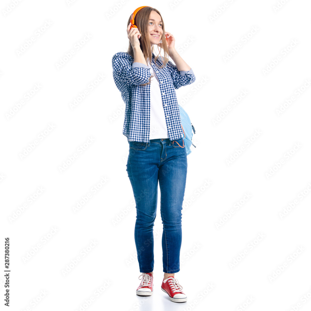 Woman in casual clothing student with backpack standing looking smiling, listening to music headphones on white background isolation Woman in casual clothing student with backpack standing looking smiling, listening to music headphones on white background isolation