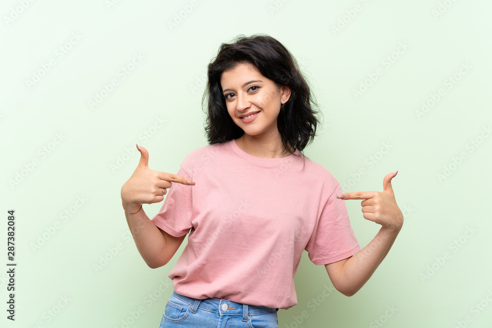 Young woman over isolated green background proud and self-satisfied Young woman over isolated green background proud and self-satisfied