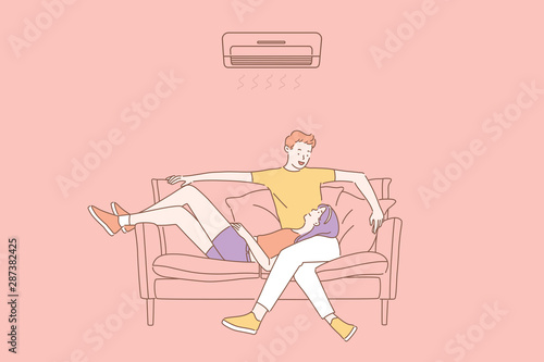 Air conditioning, climatic control, comfort concept. Couple in love relaxing under the air conditioner at home. Young happy guy and girl enjoy cool on hot summer day at home or in office.