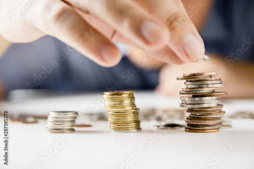 Tableau sur toile Male hand putting money coin stack growing, Saving money concept