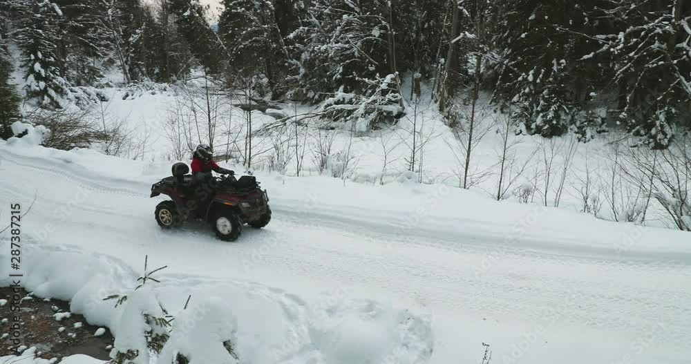 Two quad bikes are driving through snow-capped mountains on the road 4K Two quad bikes are driving through snow-capped mountains on the road 4K