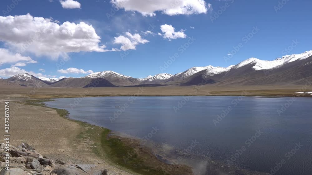 Pamir Highway Bulunkul Lake Breathtaking Picturesque View with Snow Capped Mountains at Background on a Sunny Blue Sky Day Pamir Highway Bulunkul Lake Breathtaking Picturesque View with Snow Capped Mountains at Background on a Sunny Blue Sky Day