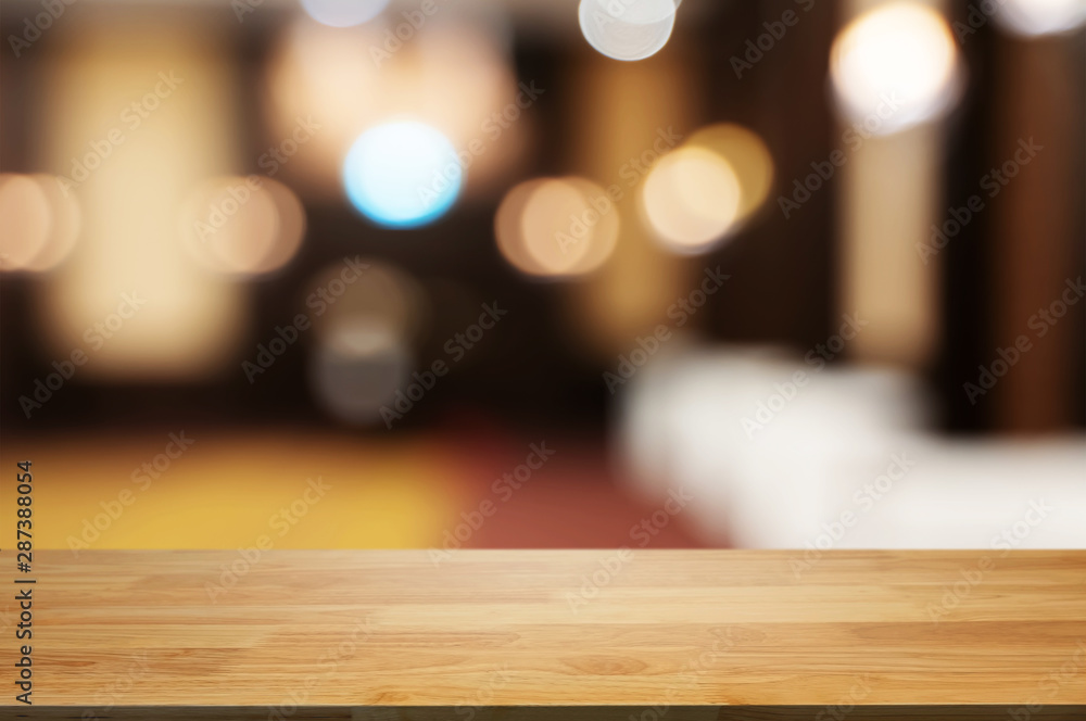 Wooden tabletop in front of montage blur restaurant cafe or kitchen background.