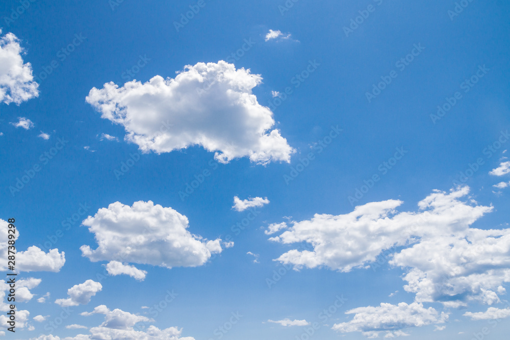 White fluffy clouds in the blue sky in summer White fluffy clouds in the blue sky in summer