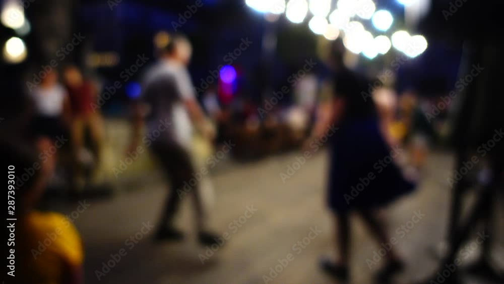 Unknown people dance the twist dance in the summer evening. Out of focus. Unknown people dance the twist dance in the summer evening. Out of focus.