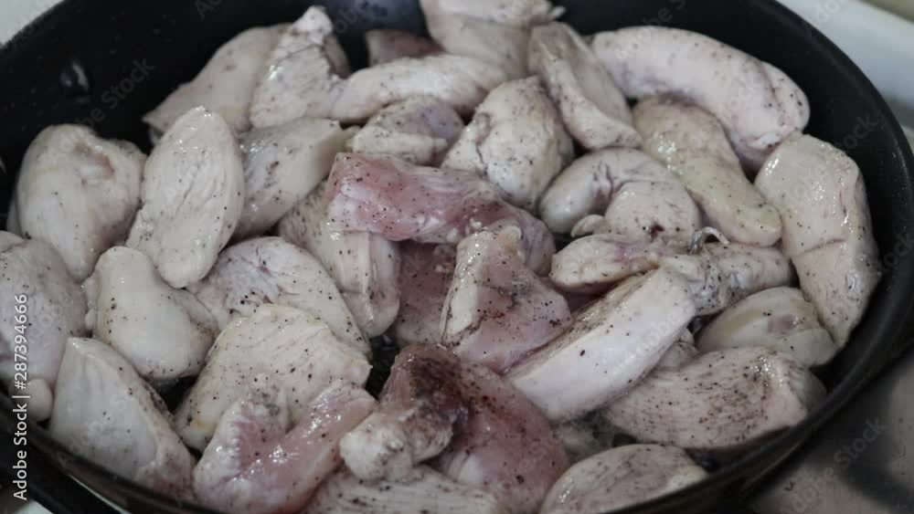 Chicken fillet sliced in small pieces slowly fried in an open close-up pan Chicken fillet sliced in small pieces slowly fried in an open close-up pan
