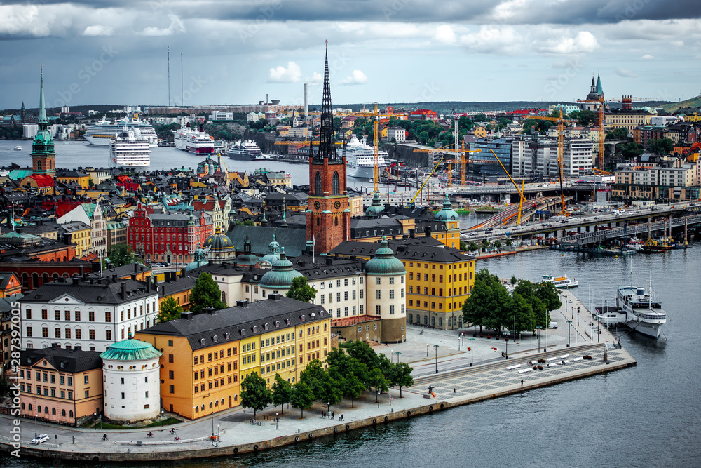 Naklejka premium Scenic summer aerial panorama of the Old Town pier architecture in Stockholm, Sweden. Aerial panorama from height of bird's flight on observation deck on tower City Hall to Gamla Stan. Travel concept