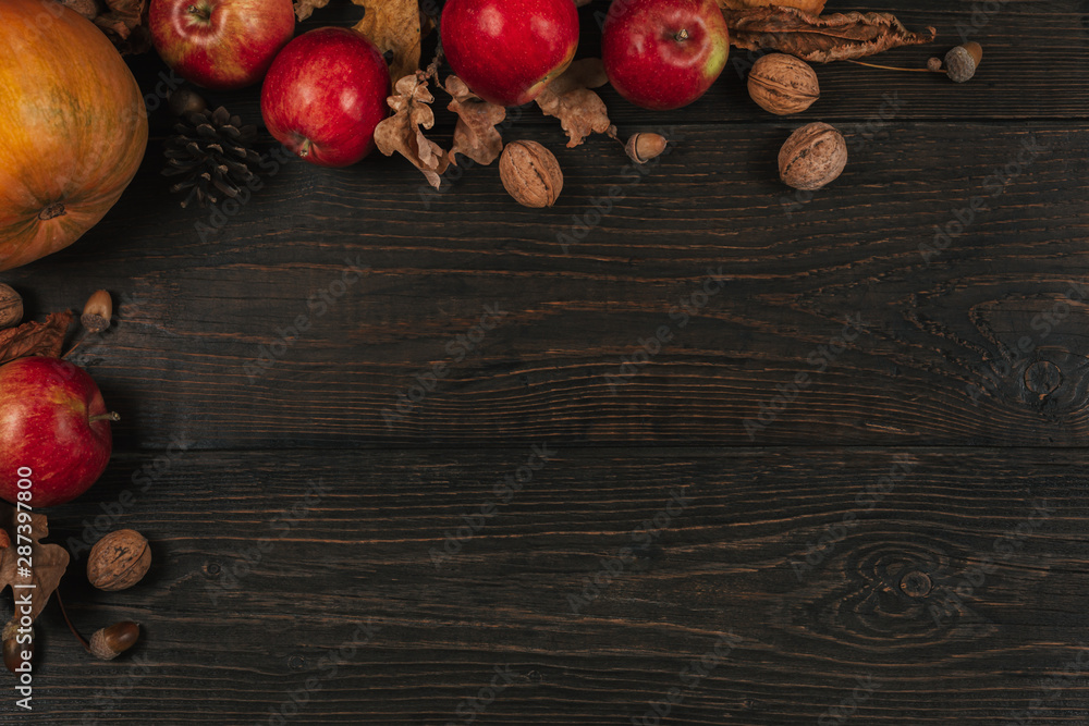 Autumn background with pumpkin, apples and nuts. Dark rustic wooden background. Autumn background with pumpkin, apples and nuts. Dark rustic wooden background.
