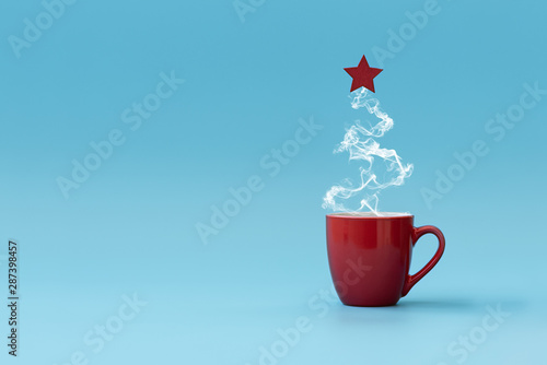 Christmas tree made of steaming coffee with red star. Morning drink. Christmas or New Year celebration concept. Copy space.