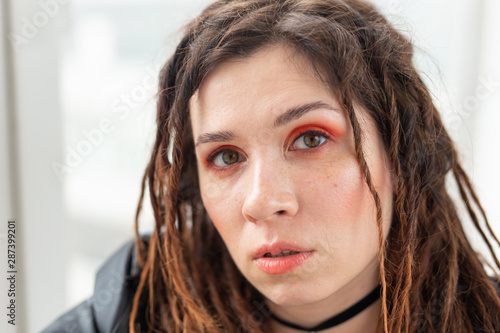 Dreadlocks, hairdresser and style concept - A stylish girl with dreadlocks and in leather jacket and fashionable makeup photo