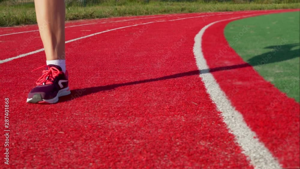 Close-up of legs in white socks and colorful running girl sneakers, slow motion, healthy lifestyle, running, outdoor sports at the stadium Close-up of legs in white socks and colorful running girl sneakers, slow motion, healthy lifestyle, running, outdoor sports at the stadium