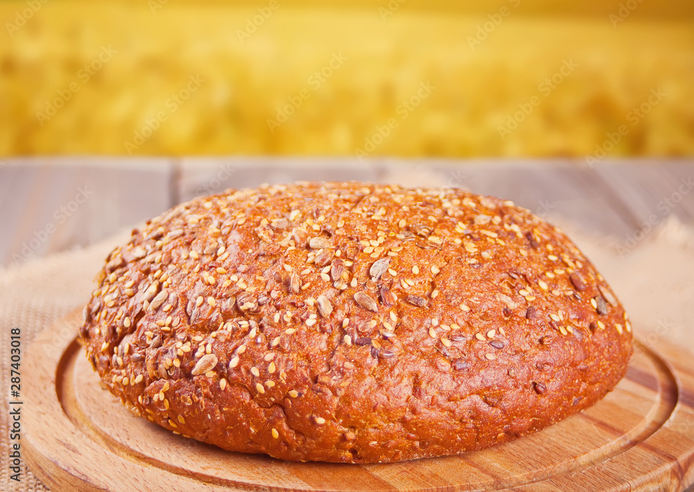 freshly baked rye bread with cereal and seeds and wheat stems on wooden kitchen table. Top view. Copy space. freshly baked rye bread with cereal and seeds and wheat stems on wooden kitchen table. Top view. Copy space.