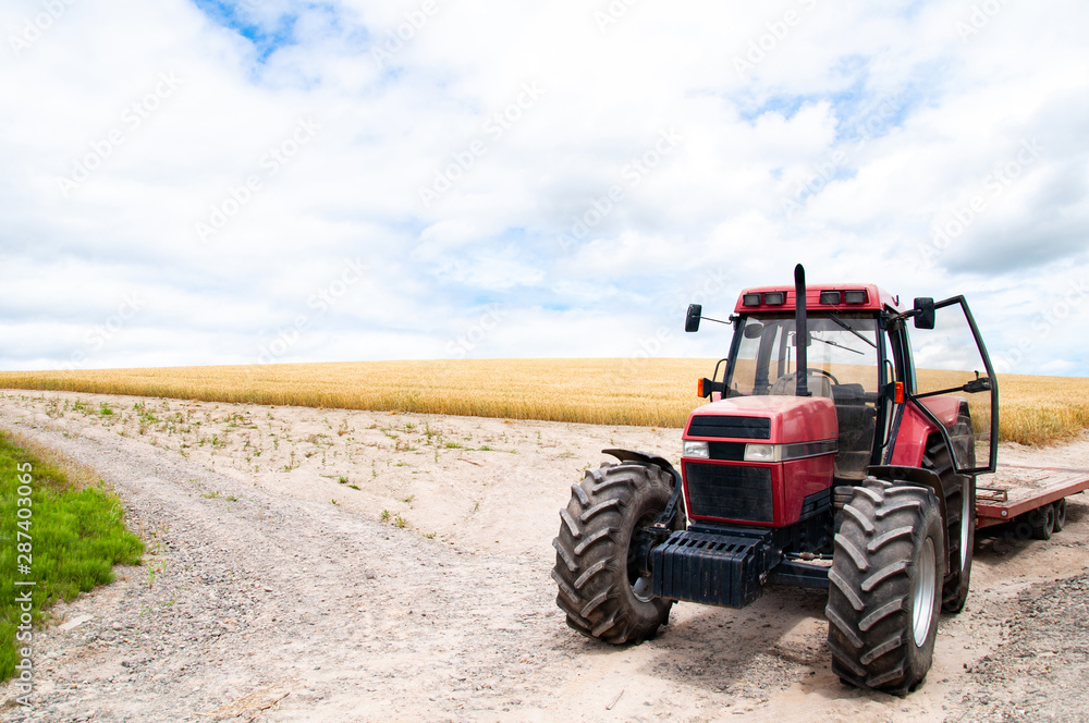 Red tractor with malt farm and cloud sky Red tractor with malt farm and cloud sky