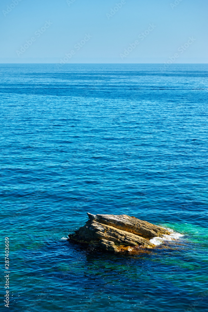 The sea horizon and lonely rock