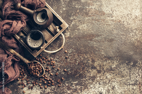 Coffee on wooden tray with coffee beans on dark textured background. Top view with copy space. Background with free text space.