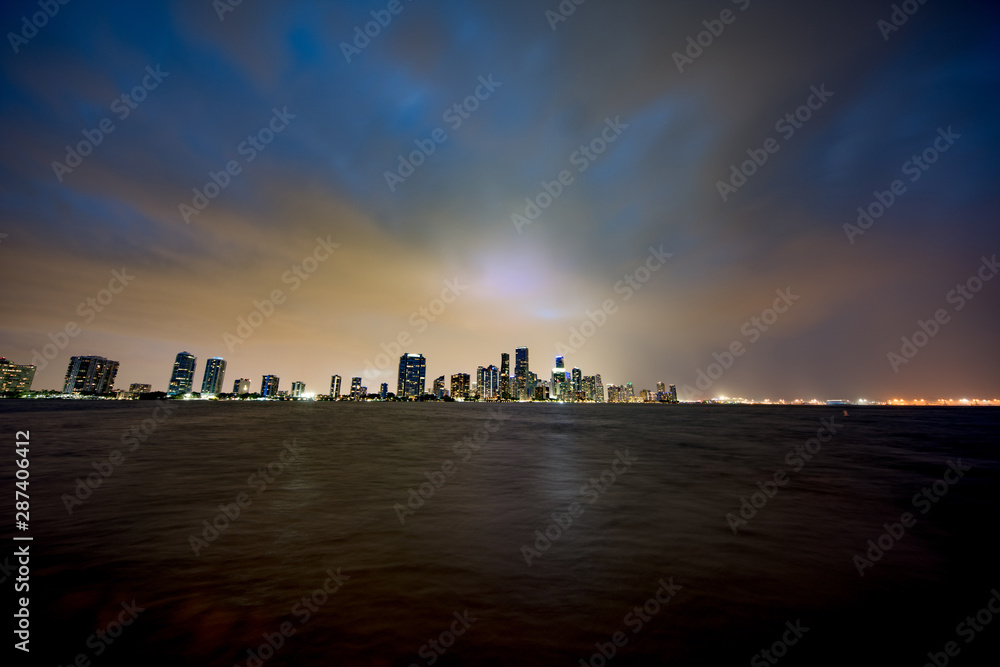 Wide angle night photo of a city wwith storm approaching moody sky