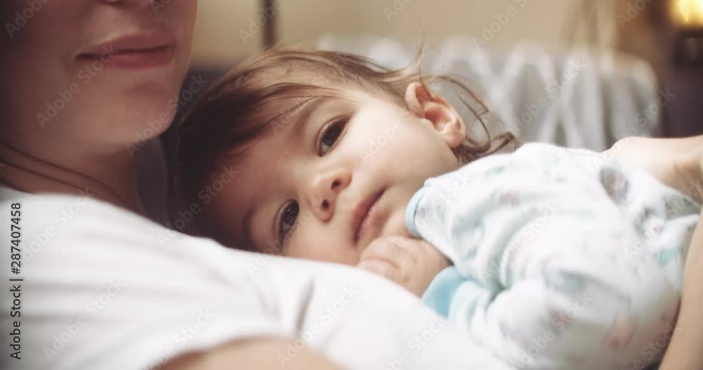 Cinematic and moody shot of baby resting on mom. Shot in 4K RAW on a cinema camera. Cinematic and moody shot of baby resting on mom. Shot in 4K RAW on a cinema camera.