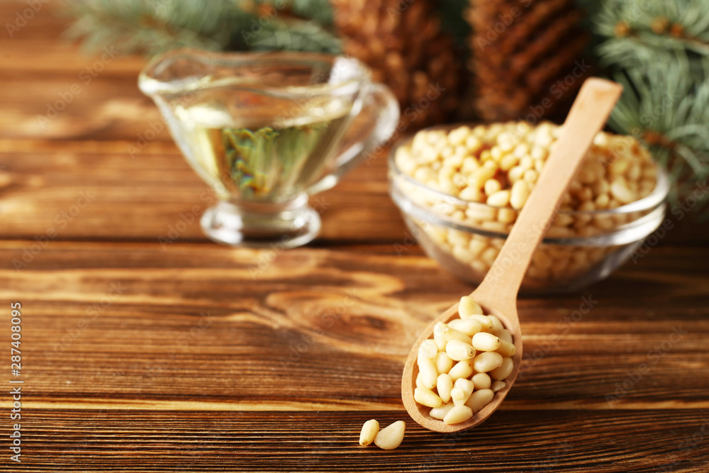 Cedar products: pine nuts, cedar oil, cones, brunches on a wooden broun background. Cedar products: pine nuts, cedar oil, cones, brunches on a wooden broun background.