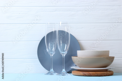 A set of dishes and kitchen utensils on a colored background.