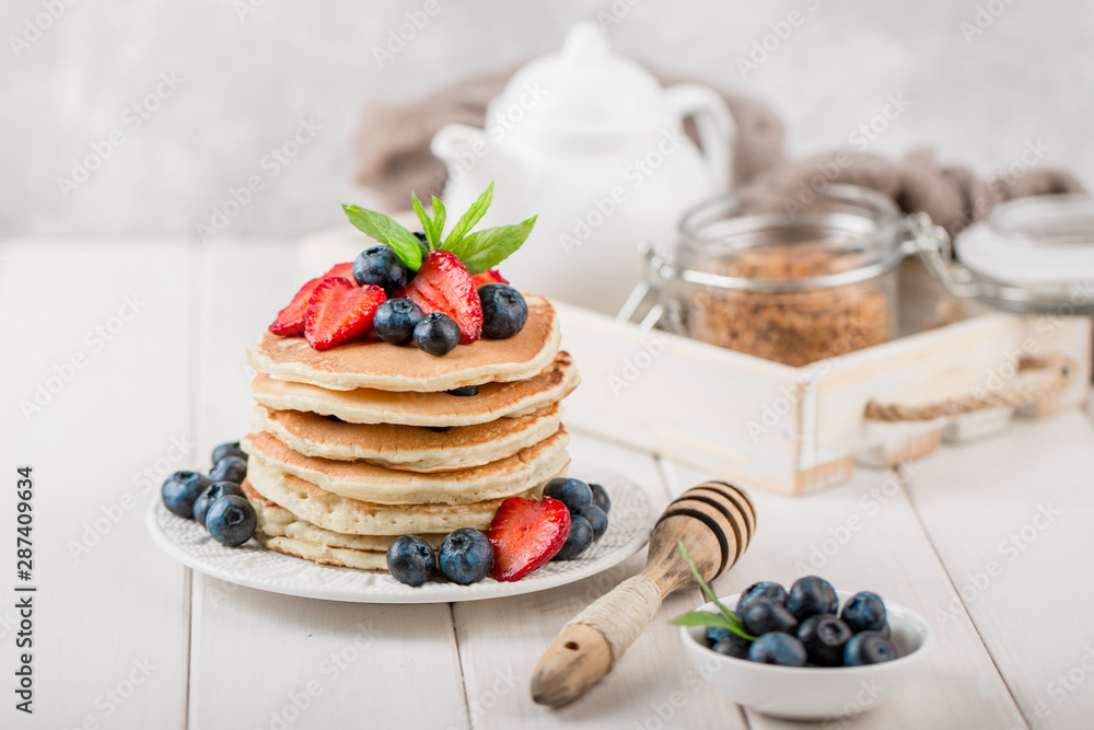 Classic american pancakes with fresh berry on white wood background. Summer homemade breakfast. Classic american pancakes with fresh berry on white wood background. Summer homemade breakfast.