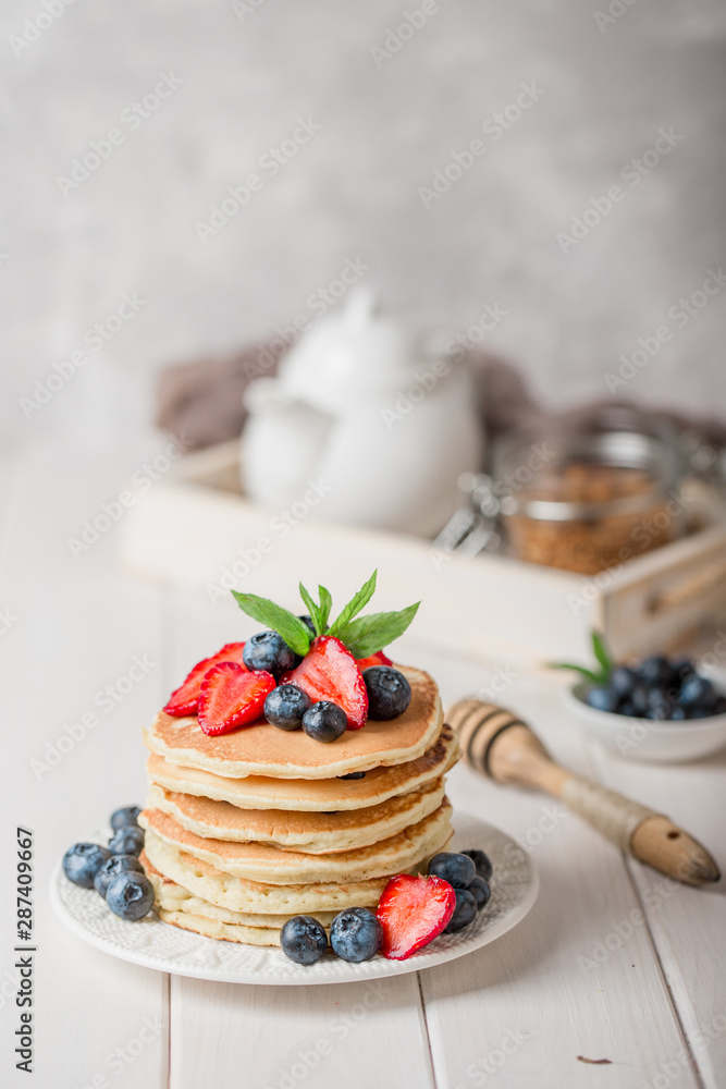 Classic american pancakes with fresh berry on white wood background. Summer homemade breakfast. Classic american pancakes with fresh berry on white wood background. Summer homemade breakfast.