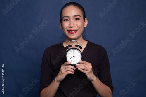 Young Asian woman smile with a clock.