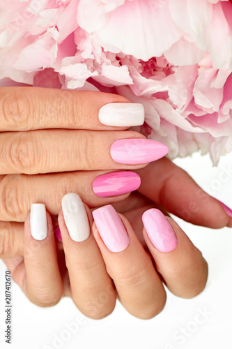 Light pink, pastel manicure on various shapes of nails with peony closeup.