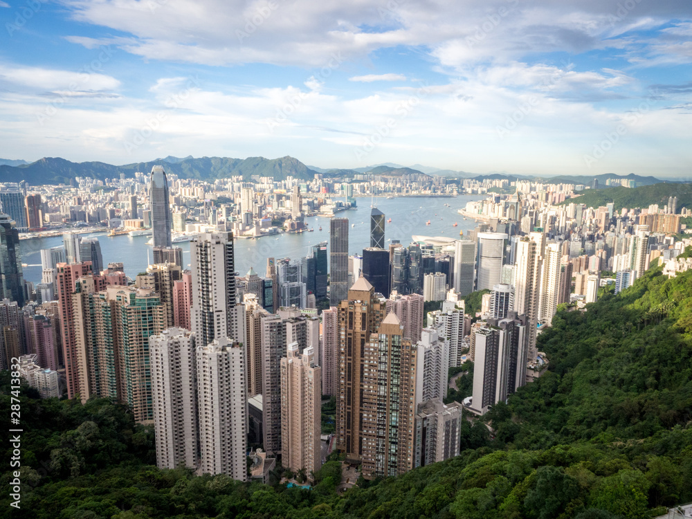 Hong Kong Skyline from the Famous Victoria Point at Daytime. Green forest and river surrounded by towering sky scrapers which is densly populated