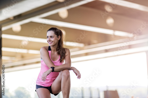 Female runner smiling during urban workout 