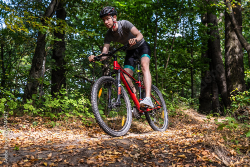 Young man biking in forest