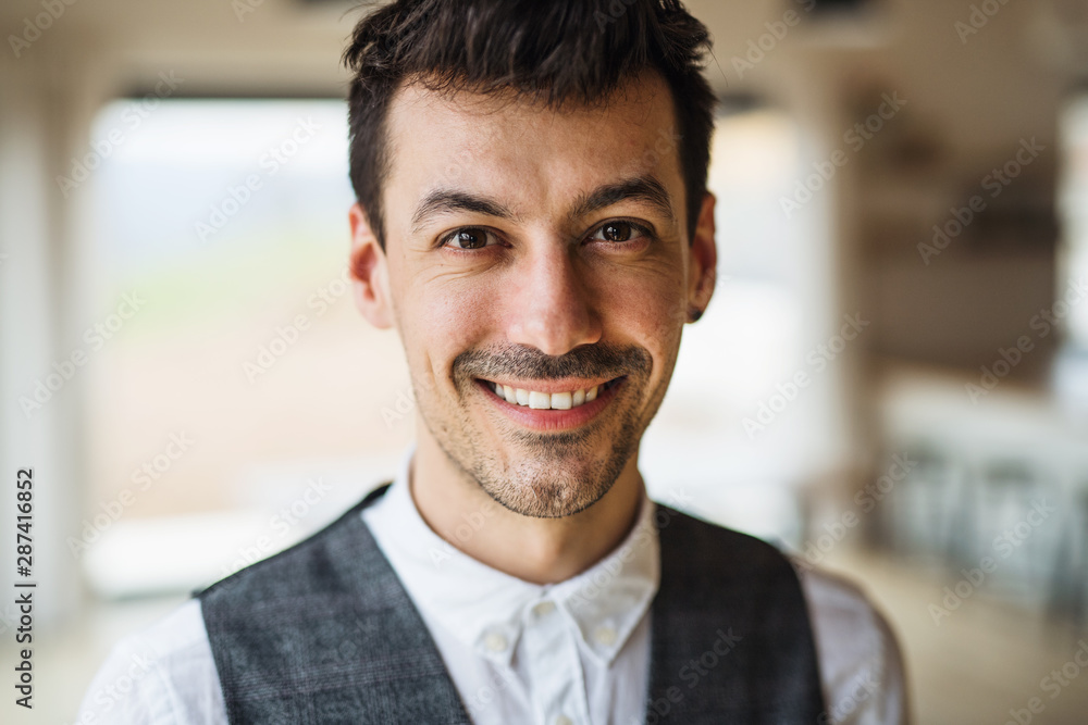 Portrait of young man standing indoors at home, looking at camera. Portrait of young man standing indoors at home, looking at camera.