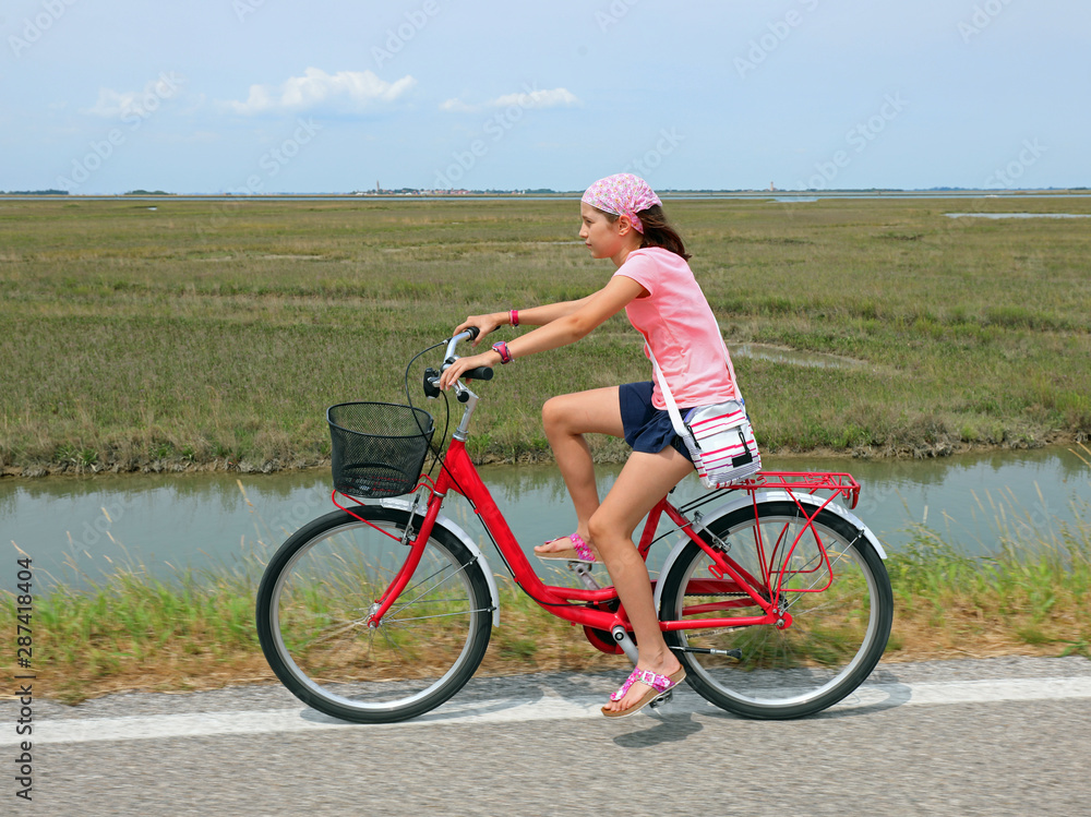 Fototapeta premium Cute little girl with bandana on the bike