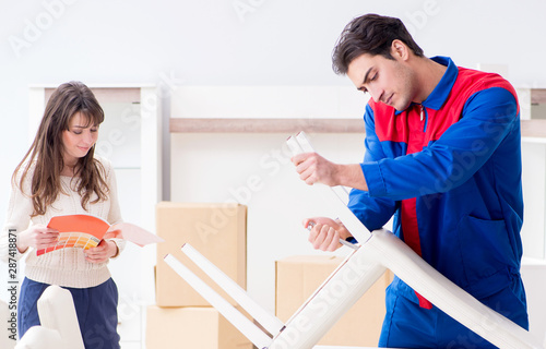 Contractor repairman assembling furniture under woman supervisio photo