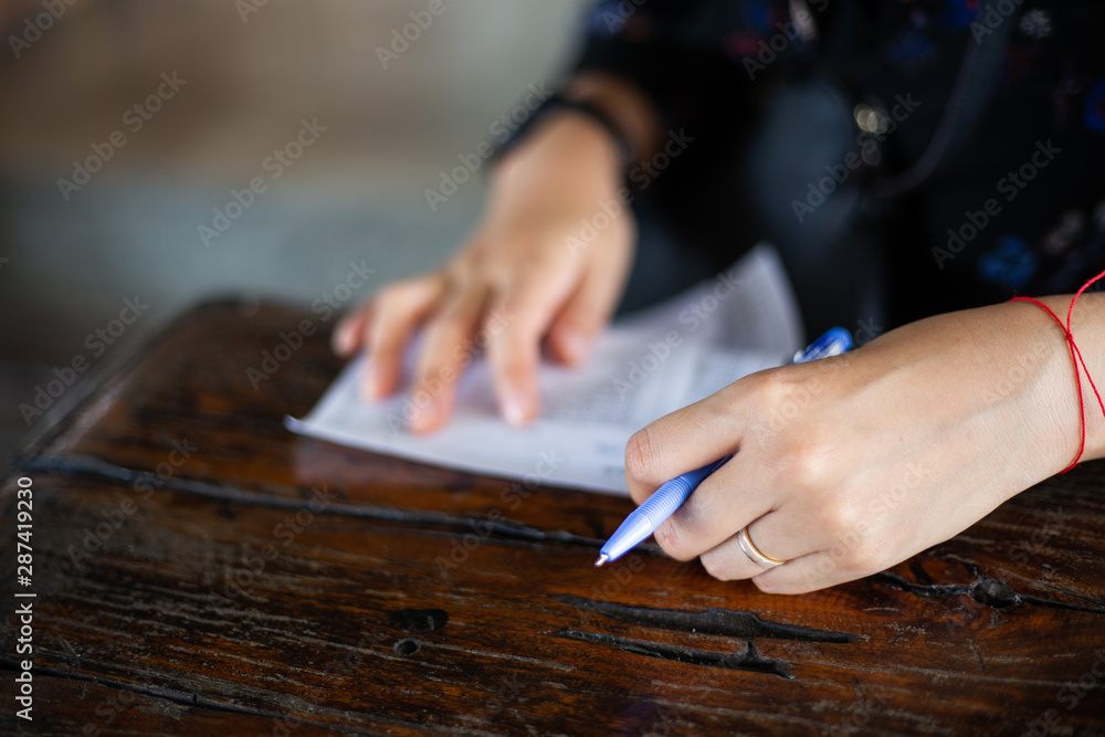 Closeup of woman's left hand writing order