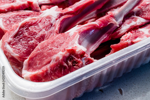 Raw Bloody Lamb Chops Meat in Plastic Package / Box or Container.