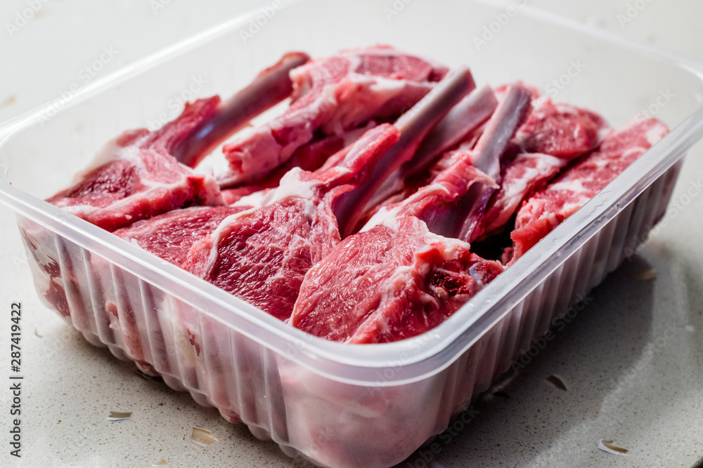 Raw Bloody Lamb Chops Meat in Plastic Package / Box or Container. Raw Bloody Lamb Chops Meat in Plastic Package / Box or Container.