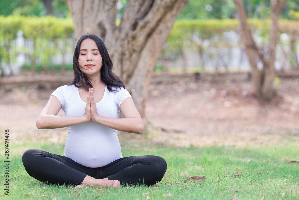 Portrait of asian Beautiful pregnant woman at the park,Thailand people,Happy woman concept,Her play yoga on the lawn Portrait of asian Beautiful pregnant woman at the park,Thailand people,Happy woman concept,Her play yoga on the lawn