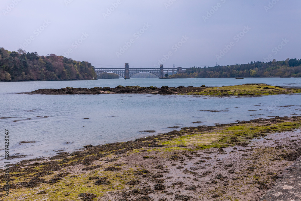The Menai Strait is a narrow stretch of shallow tidal water about 25 km long, which separates the island of Anglesey from the mainland of Wales. 