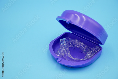 clear plastic retainer teeth in the box set isolated on blue sky background. it's an equipment for orthodontist give the patient to orthodontic surgery in dental clinic or hospital