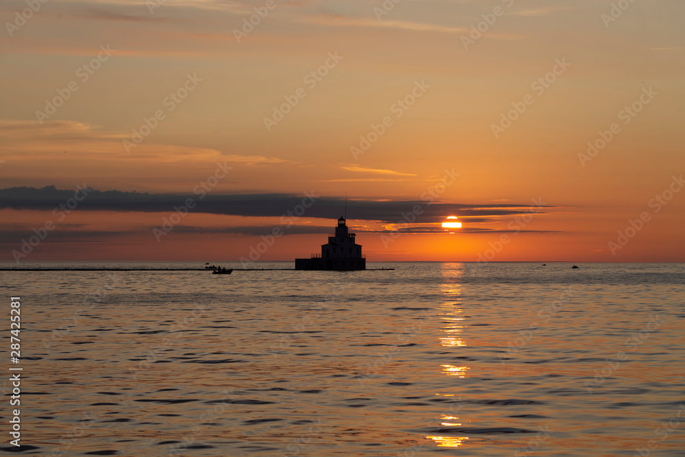 sunrise over lake and mouth of Manitowoc river Lighthouse at Manitowoc Harbor on Lake Michigan in Wisconsin sunrise over lake and mouth of Manitowoc river Lighthouse at Manitowoc Harbor on Lake Michigan in Wisconsin