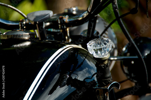 Close up of crystal diamond shaped doorknob used as shifter on old black vintage motorcycle.
