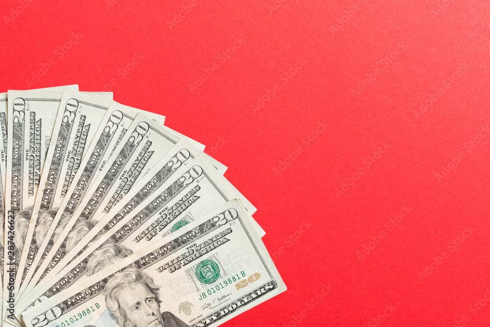 US Dollars: Untidy fan of various US dollar bills Top view of business concept on colored background US Dollars: Untidy fan of various US dollar bills Top view of business concept on colored background