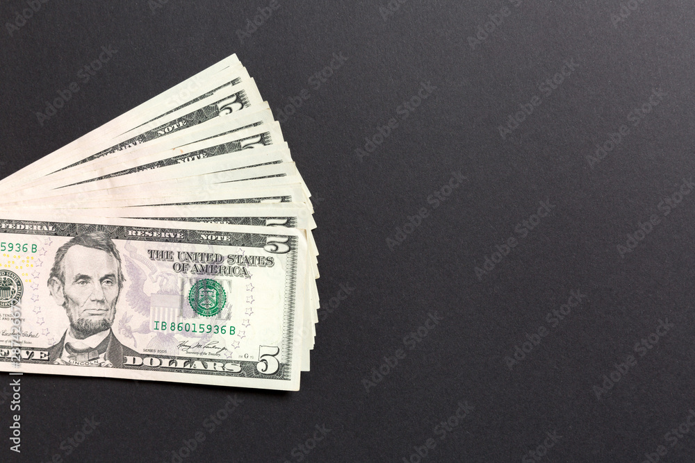 Stack of 5 dollar banknotes on colorful background. Top view of financial concept with empty space for your design Stack of 5 dollar banknotes on colorful background. Top view of financial concept with empty space for your design