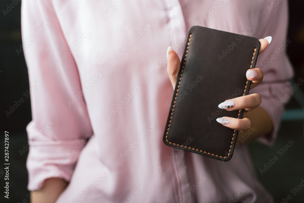 Obraz premium a leather case for the phone in the girl s hand
