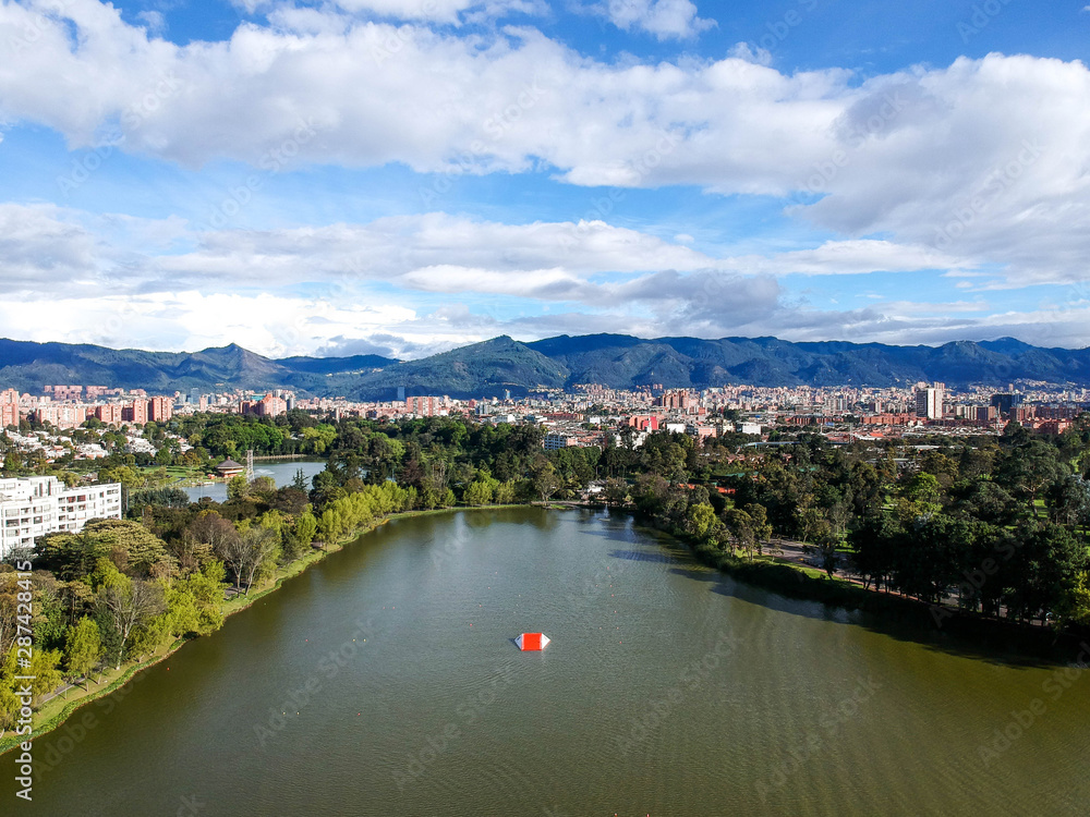 Fototapeta premium Areal view of bogota whit a blue sky with clouds, residential area with a lake, you can see the city and the mountain 