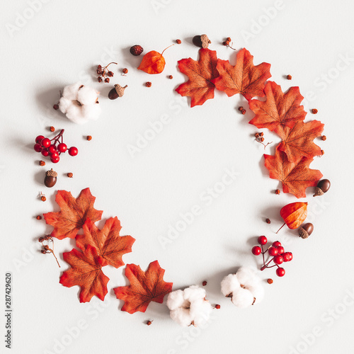 Autumn composition. Wreath made of flowers, maple leaves on gray background. Autumn, fall, thanksgiving day concept. Flat lay, top view, copy space
