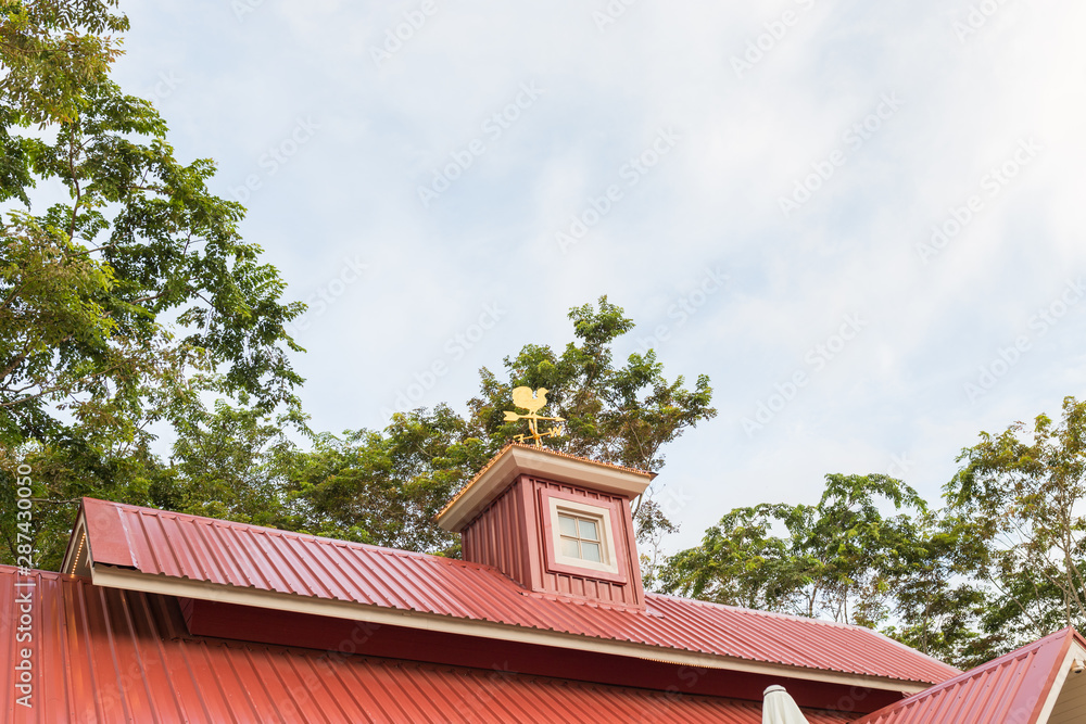 Chicken wind measure direction on the top of roof against blue sky. Chicken wind measure direction on the top of roof against blue sky.